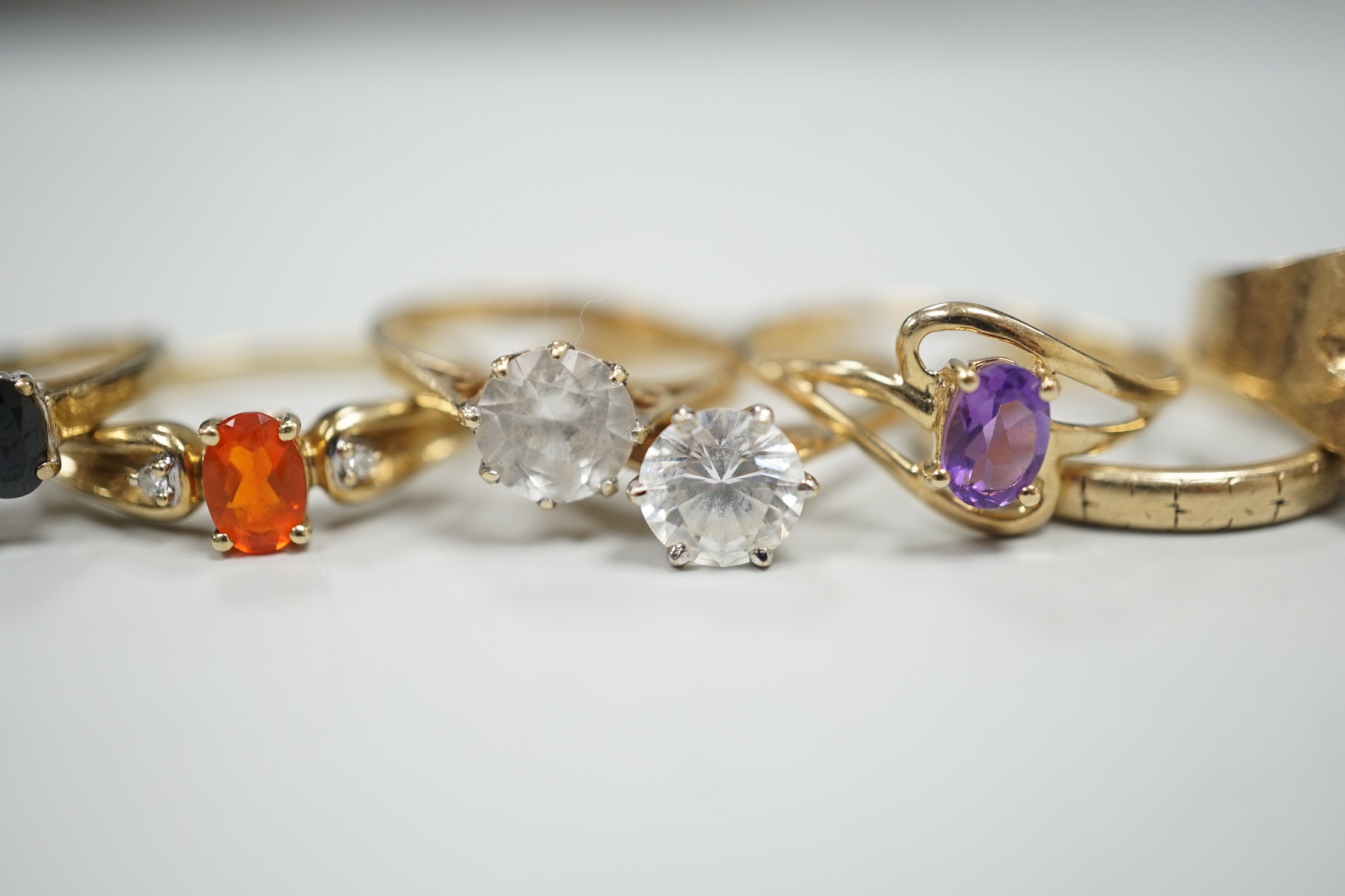 Six assorted modern 9ct gold and gem set rings, including amethyst and garnet single stone rings, together with a 9ct gold wedding band, gross weight 15.2 grams.